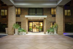 Holiday Inn Express Hotel & Suites Columbia-I-20 at Clemson Road, an IHG Hotel في كولومبيا: لوبي فاضي من عماره فيها باب كبير