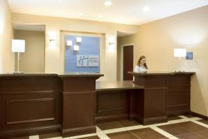 a woman standing at a reception desk in a hotel room at Holiday Inn Express Le Roy, an IHG Hotel in Le Roy