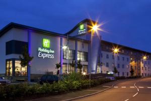 a building with neon signs on the side of it at Holiday Inn Express Walsall M6, J10, an IHG Hotel in Walsall