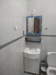 een badkamer met een wastafel, een spiegel en een toilet bij Style Malargue a 100 mtrs del centro,ubicadisimo in Malargüe