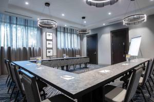 Staybridge Suites - Quincy, an IHG Hotel في كوينسي: قاعة المؤتمرات مع طاولة وكراسي طويلة