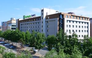 a large white building with trees in front of it at Holiday Inn Express Changchun High-Tech Zone by IHG in Changchun