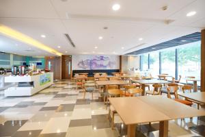 a restaurant with tables and chairs in a cafeteria at Holiday Inn Express Changchun High-Tech Zone by IHG in Changchun