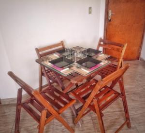 a dining room table with four wooden chairs and a glass table at Aconchegante e próximo à natureza! in Curitiba