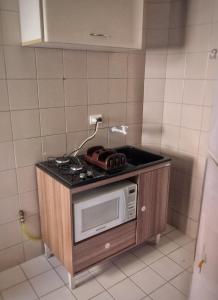 a microwave sitting on top of a stove in a kitchen at Aconchegante e próximo à natureza! in Curitiba