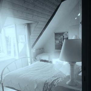 サン・カスト・ル・ギドにあるMaison du portのベッドルーム(白いベッド1台、ランプ付)