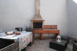 
a wooden table with a fire place next to a brick wall at Home of pilgrims d`Apúlia in Apúlia
