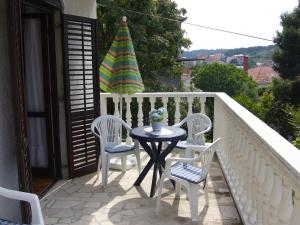 a patio with a table and chairs on a balcony at Apartments Barić in Trogir