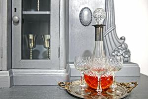 una botella de vino en una bandeja con tres copas de vino en Natalie's Home, en Belgrado