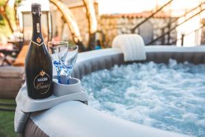 een fles champagne en een glas naast een hot tub bij Jamm - Apartment with hot tub and terraces in Massa Lubrense