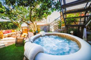 een grote hot tub in de tuin met een patio bij Jamm - Apartment with hot tub and terraces in Massa Lubrense