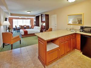 a hotel room with a kitchen and a bedroom at Holiday Inn Express Hotel & Suites Cape Girardeau I-55, an IHG Hotel in Cape Girardeau