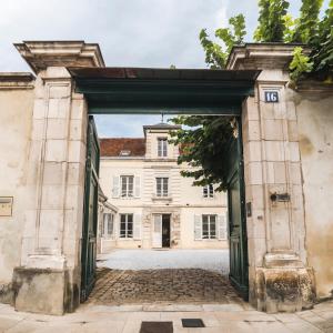 una entrada a un edificio antiguo con una puerta abierta en La Villa Ribière en Auxerre