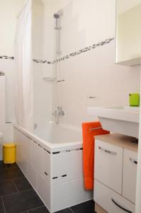 ein weißes Bad mit einer Dusche und einem Waschbecken in der Unterkunft Guesthouse Casa Esperanza Basel in Basel