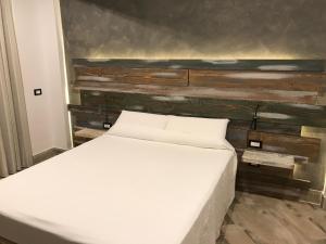 聖喬治阿克雷馬諾的住宿－Domus Vesuvio，木墙客房内的一张白色床