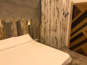 サン・ジョルジョ・ア・クレマーノにあるDomus Vesuvioの木製の壁の客室の白いベッド1台