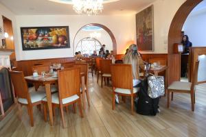 una donna seduta a un tavolo in un ristorante di Hotel Carolina Montecarlo a Quito