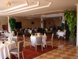 una sala banchetti con tavoli e sedie bianchi di Hôtel Atlantique Panorama a Safi