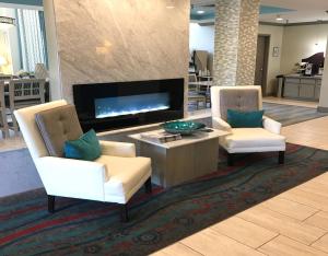 een woonkamer met 2 witte stoelen en een tv bij Holiday Inn Express & Suites Brookhaven, an IHG Hotel in Brookhaven