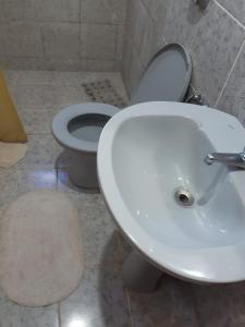 a bathroom with a white toilet and a sink at Apartamento do Sr Luiz e dona cida in Lambari +9 photos
