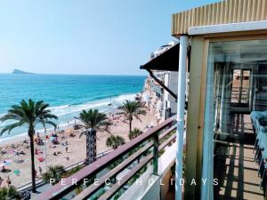 a balcony view of a beach with palm trees and the ocean at España Playa in Benidorm
