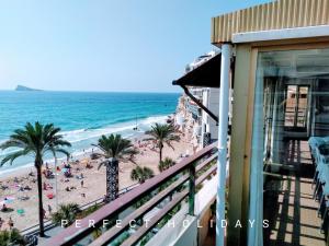 balkon z widokiem na plażę z palmami i ocean w obiekcie España Playa w mieście Benidorm