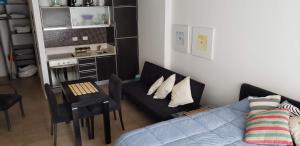 a living room with a couch and a table and a kitchen at Puerto Madero con Amenities in Buenos Aires