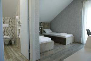 um pequeno quarto com uma cama e um banheiro em Fine Suites em Niš