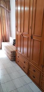 リオデジャネイロにあるApartameto 307 Copacabana posto 3のベッドルーム1室(ベッド1台付)、大きな木製キャビネットが備わります。 +4枚の写真