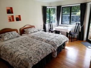 a bedroom with a bed and a table and chairs at The Little Gem in Waitara