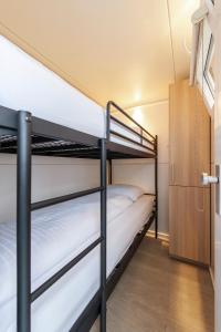 Tiny floating house Ibiza في ماستريخت: غرفة بسرير بطابقين