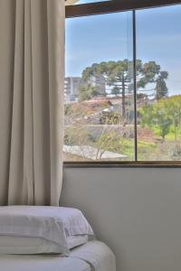 São MarcosにあるHotel São Marcosの窓とベッドが備わる客室で、ベッドスカートスペクトが付いています。