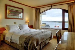 a hotel room with a bed and a window at Hotel Cabaña Del Lago Puerto Varas in Puerto Varas