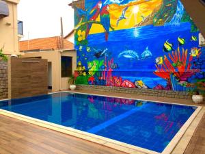 a swimming pool with a fish mural on the wall at Pousada Pinheiro in Campos dos Goytacazes