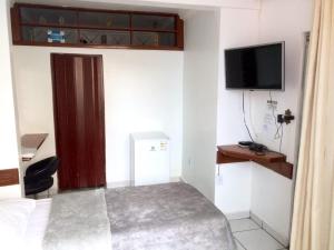 a small room with a bed and a television at Pousada Pinheiro in Campos dos Goytacazes