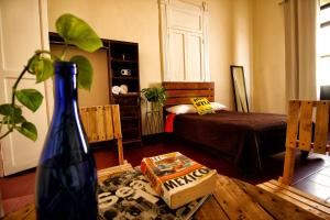 a room with a bedroom with a bed and a vase at Hostel Hospedarte Centro in Guadalajara