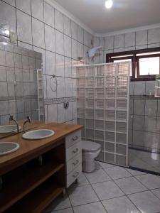 a bathroom with two sinks and a toilet in it at iUP HOUSE Hostel in Blumenau