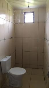 a bathroom with a toilet and a window at Chales Jeitinho Mineiro in São Thomé das Letras