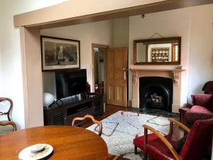 a living room with a table and a fireplace at Eliza cottage in Hobart