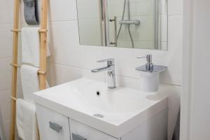 łazienka z białą umywalką i lustrem w obiekcie CRISTINE APARTMENT w Warszawie +15 zdjęć