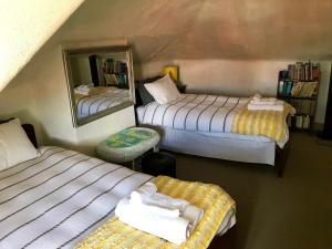 ein Schlafzimmer mit zwei Betten und einem Spiegel in der Unterkunft Eliza cottage in Hobart