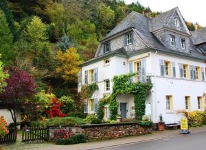 a white house with a stone wall at Ferienwohnungen-In-Bacharach in Bacharach