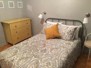 a bedroom with a bed with pillows and a night stand at Le Milka II in Longueuil