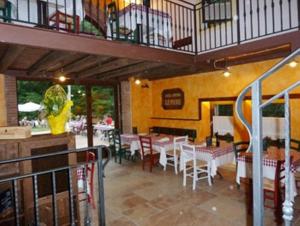 Pigozzo的住宿－洛坎達阿爾康芬- 歐斯特里亞皮埃爾住宿加早餐旅館，一间带桌椅的餐厅以及一个阳台