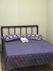 Una cama con dos toallas enrolladas. en Pousada do Alemão - Cananéia, en Cananéia