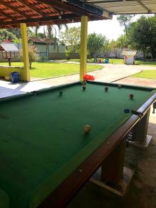 a green pool table with balls on top of it at Pousada do Alemão - Cananéia in Cananéia