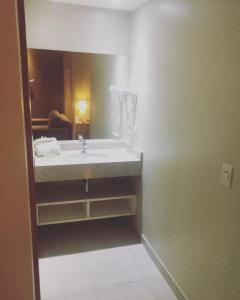 HOT SPRINGS HOTEL Caldas Novas-FLAT VIP في كالدس نوفاس: حمام مع حوض ومرآة
