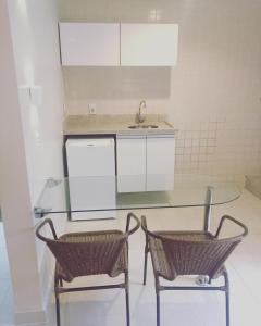 eine Küche mit einem Glastisch und 2 Stühlen in der Unterkunft HOT SPRINGS HOTEL Caldas Novas-FLAT VIP in Caldas Novas