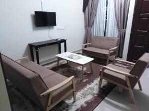 sala de estar con sofá, sillas y mesa en PATIN GUEST HOUSE @DESA TELOK IRA, TEMERLOH PAHANG, en Kampong Paya Kerinau