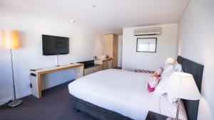 a hotel room with a bed and a television at Scenic Hotel Te Pania in Napier